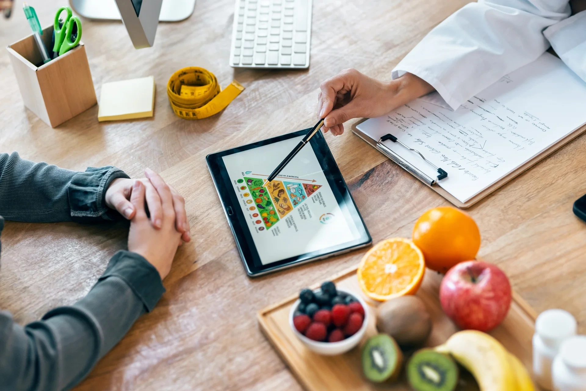 Ernährungsberatung mit Ernährungspyramide auf dem Tablet